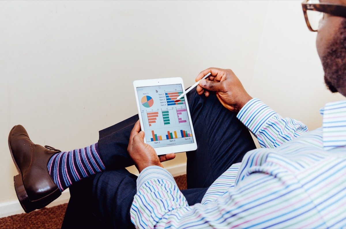 business man using a tablet with charts representing social media ads kpis and metrics