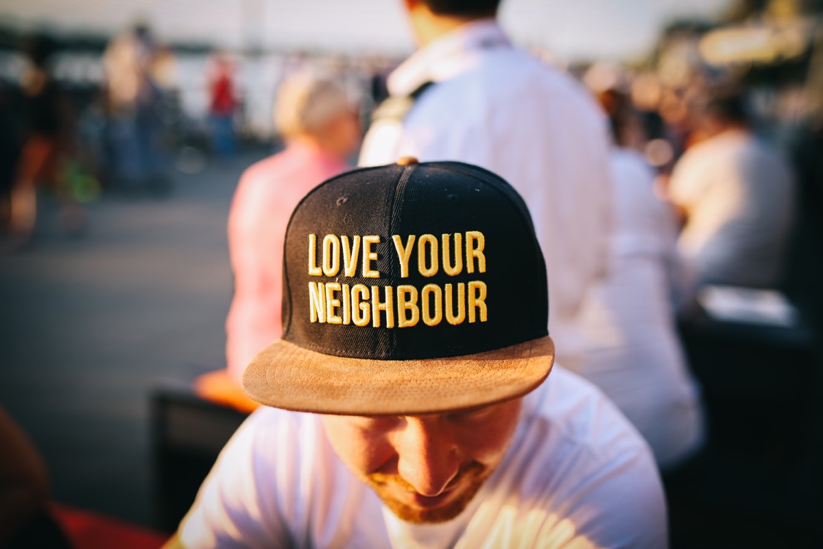 man wearing hat that says: love your neighbor; representing the importance of a localized web presence