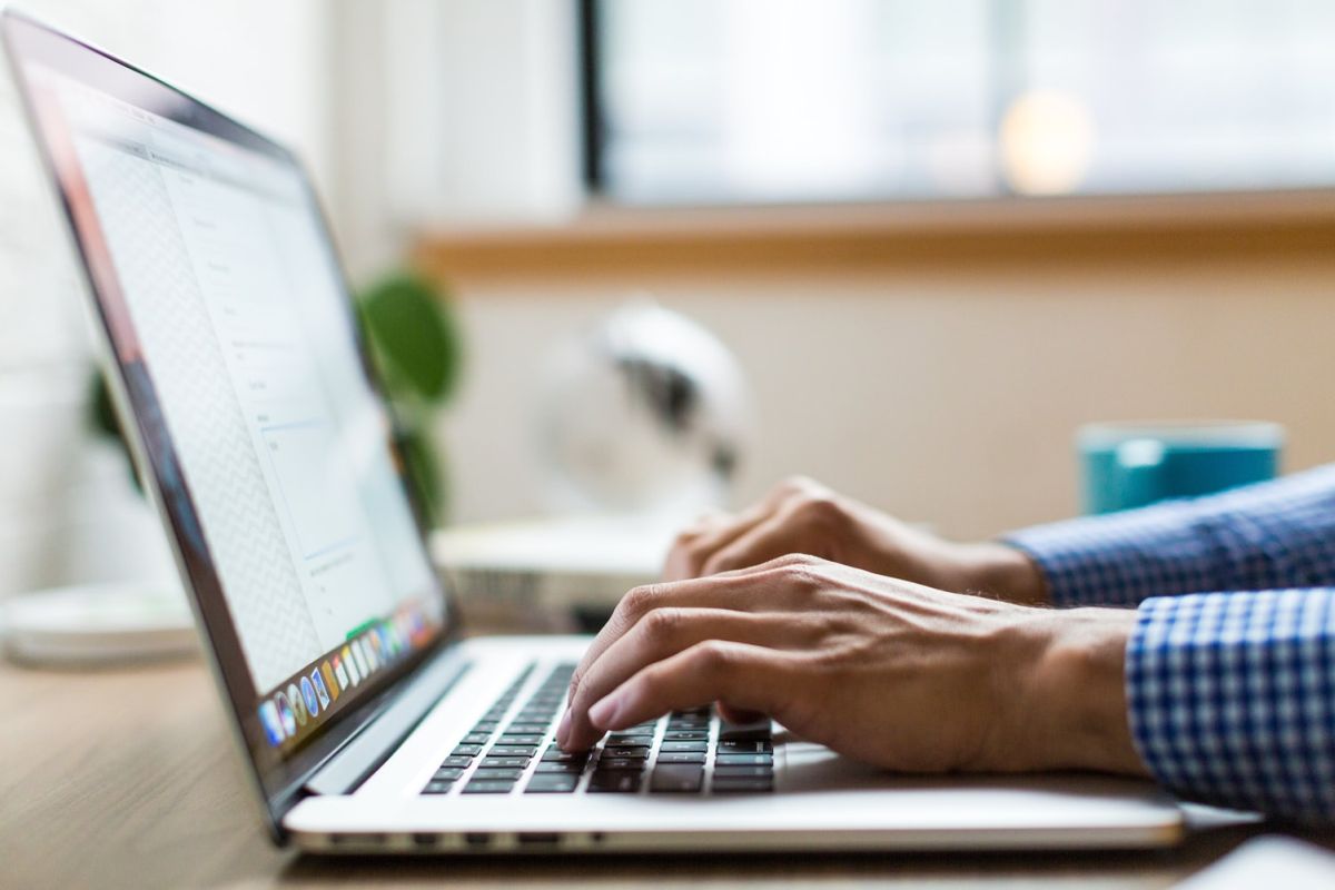 hands typing on a laptop; positive reviews responses concept